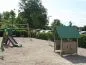 Preview: Spielhaus Beth between other play equipment on the playground Preview: Spielhaus Beth between other play equipment on the playground